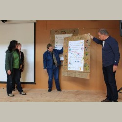 Kate Zebrowksi, Susan Roney-O'Brien, Nancy Baille Strong presenting their renga on a large sheet of paper