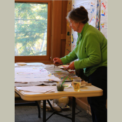 A woman painting a renga on a large sheet of paper
